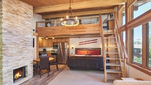 Ein Schlafzimmer im Loft-Stil mit Bett, Kamin, Essbereich und Küche.