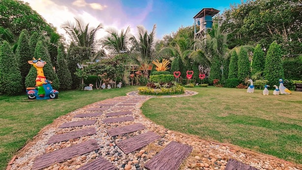 A garden pathway with decorative elements and statues. - Baan Suan  Meetang Resort (Chanthaburi)