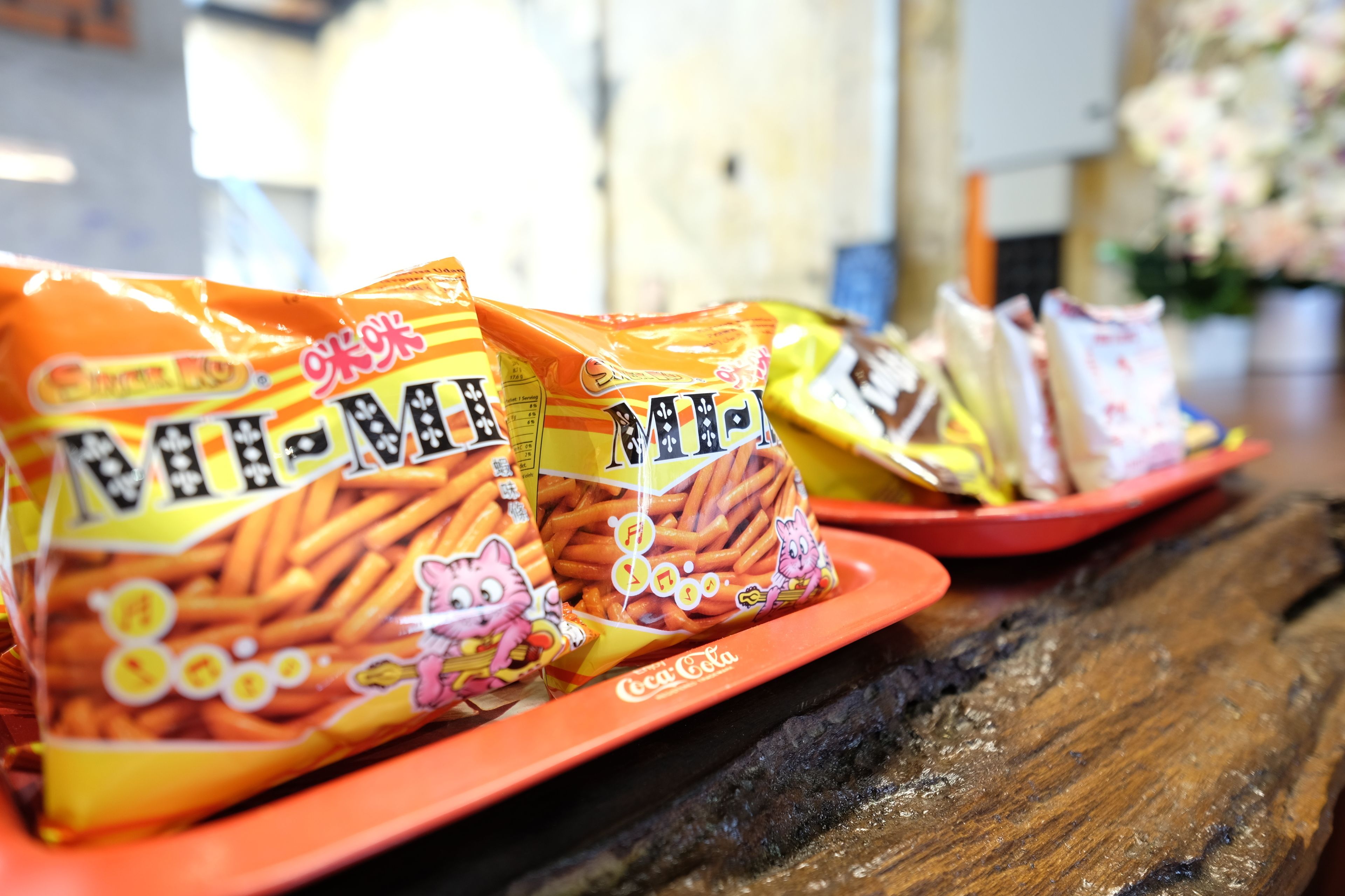 A table with bags of snacks and a Coca-Cola branded plate.