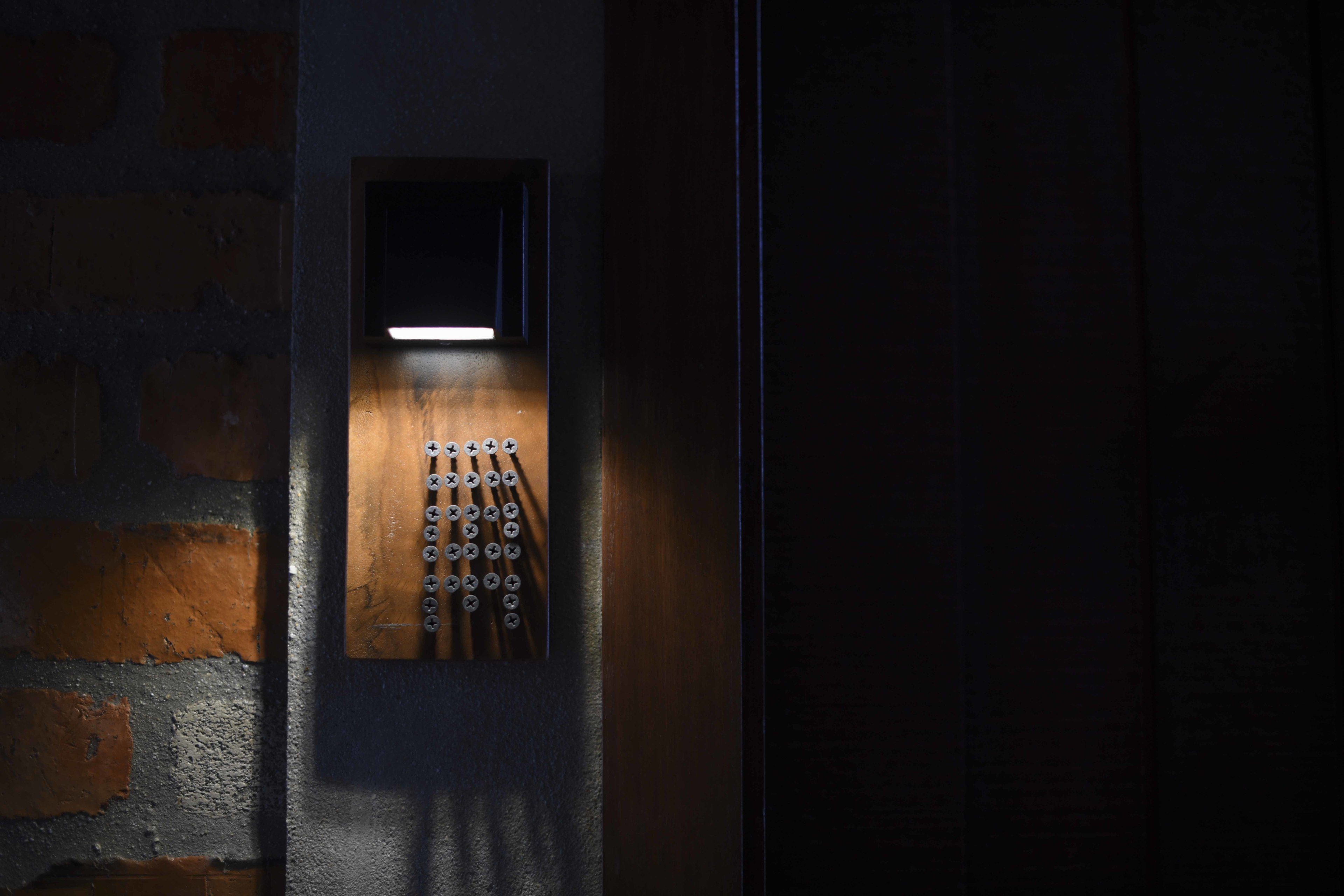 An elevator with a wooden panel and a series of buttons.