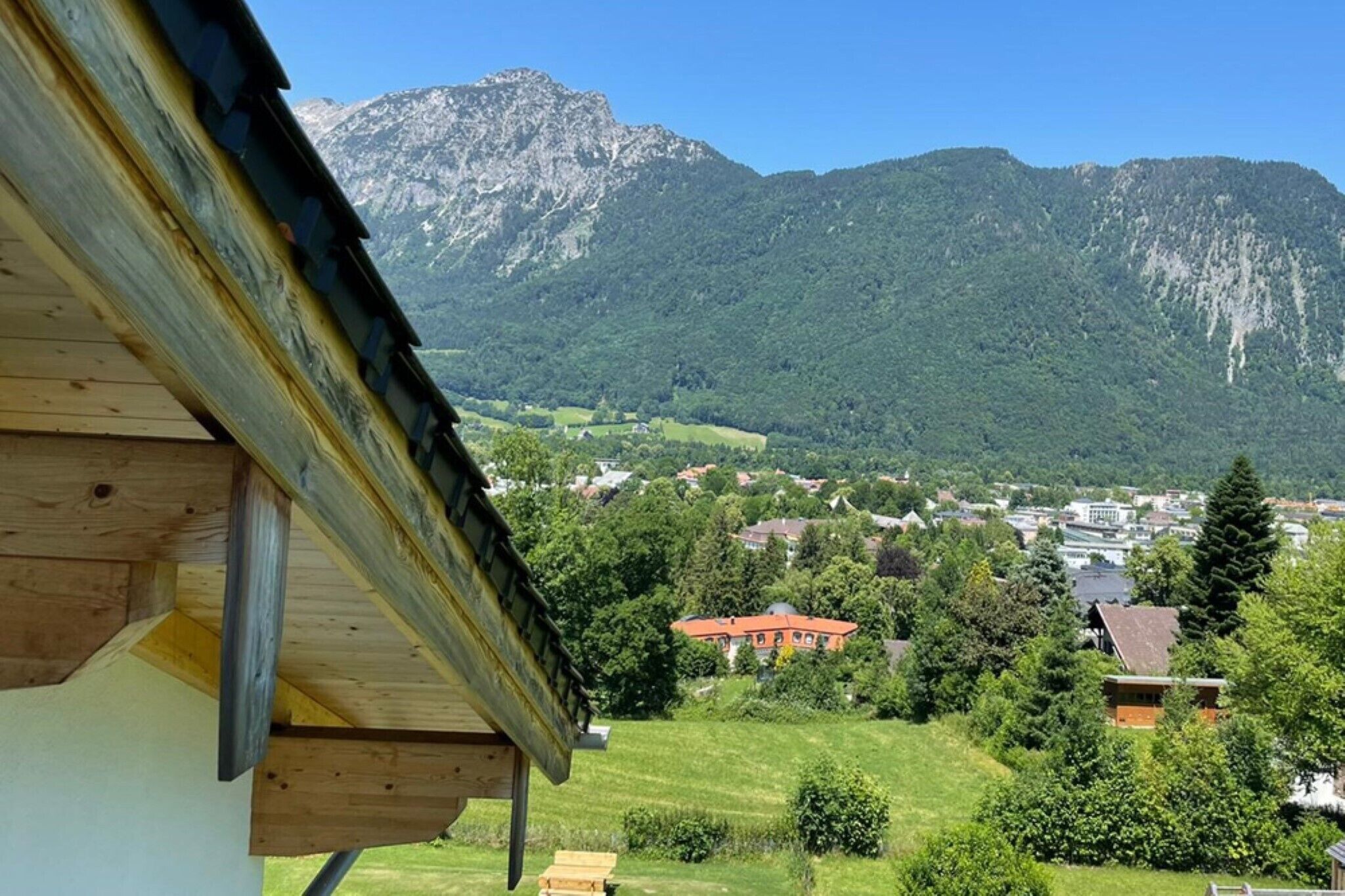 Vista de la montaña con un edificio de madera en primer plano.