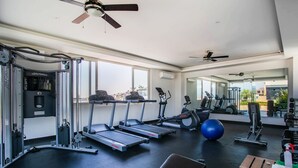 Un gimnasio moderno con cintas de correr, elípticas y pesas libres.