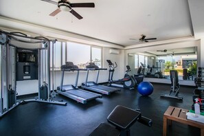 Une salle de sport moderne équipée de tapis de course, de ballons d’exercice et d’appareils de musculation.