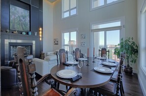 Un área de comedor con una mesa redonda para cuatro personas, una chimenea y vistas a la ciudad.