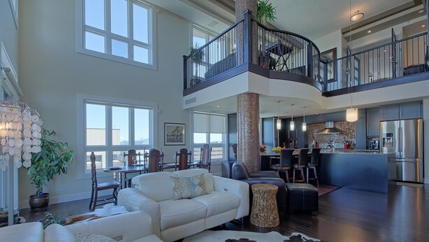 A spacious living area with a high ceiling, a dining area, and a kitchen. - Luxury Penthouse Oasis, Rooftop Patio, River View, Downtown (Edmonton)
