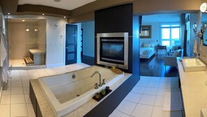 A modern bathroom with a large bathtub, a separate shower area, and a vanity with a mirror. - Luxury Penthouse Oasis, Rooftop Patio, River View, Downtown (Edmonton)