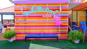 A colorful wall with horizontal stripes and a pink elephant decoration. - Khuntim Homestay Koh Rat (Koh Samui)