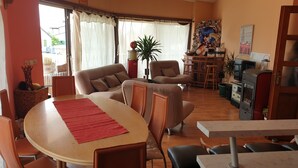 A cozy living room with a dining table, chairs, sofas, and a TV. - Poreč Sunshine (Porec)
