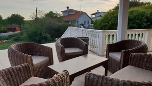 A patio with wicker furniture and a white railing. - Poreč Sunshine (Porec)