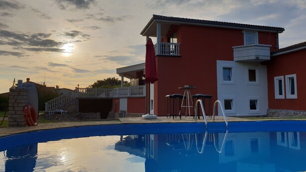 A swimming pool with a clear sky and a red building in the background. - Poreč Sunshine (Porec)