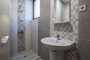A bathroom with a shower, a sink, and a mirror. - Flamingo Plovdiv (Plovdiv)