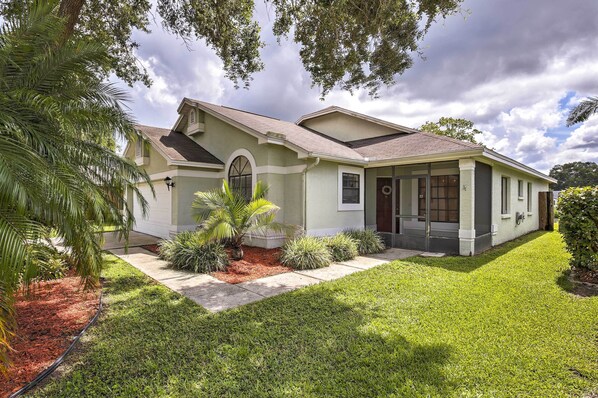 A single-story house with a sloped roof, a front porch, and a well-maintained lawn. - Lakefront Brandon Home w/ Patio & Screened Lanai! (Brandon)