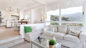 A modern living room with a sofa set, a glass coffee table, and a view of the outdoors. - Beautiful apartment for 4 people with WIFI, TV and terrace (Tossa De Mar)