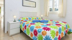 A bedroom with a bed, two bedside tables, a window with curtains, and a framed picture on the wall. - Lovely apartment for 5 people with WIFI, TV, terrace and pets allowed (Grifeu)