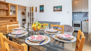 A dining area with a glass table, wooden chairs, and a fruit basket. - Nice apartment for 5 people with WIFI, A/C, TV, terrace and pets allowed (Santa Isabel)