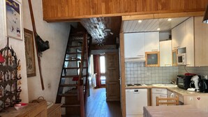 A rustic kitchen with wooden cabinets, a microwave, a toaster, and a coffee maker. - Comfortable 80sqm duplex in Tignes, 4 bedrooms, near slopes (Tignes)