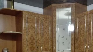 Een keuken met houten kastjes, een magnetron en een spoelbak.