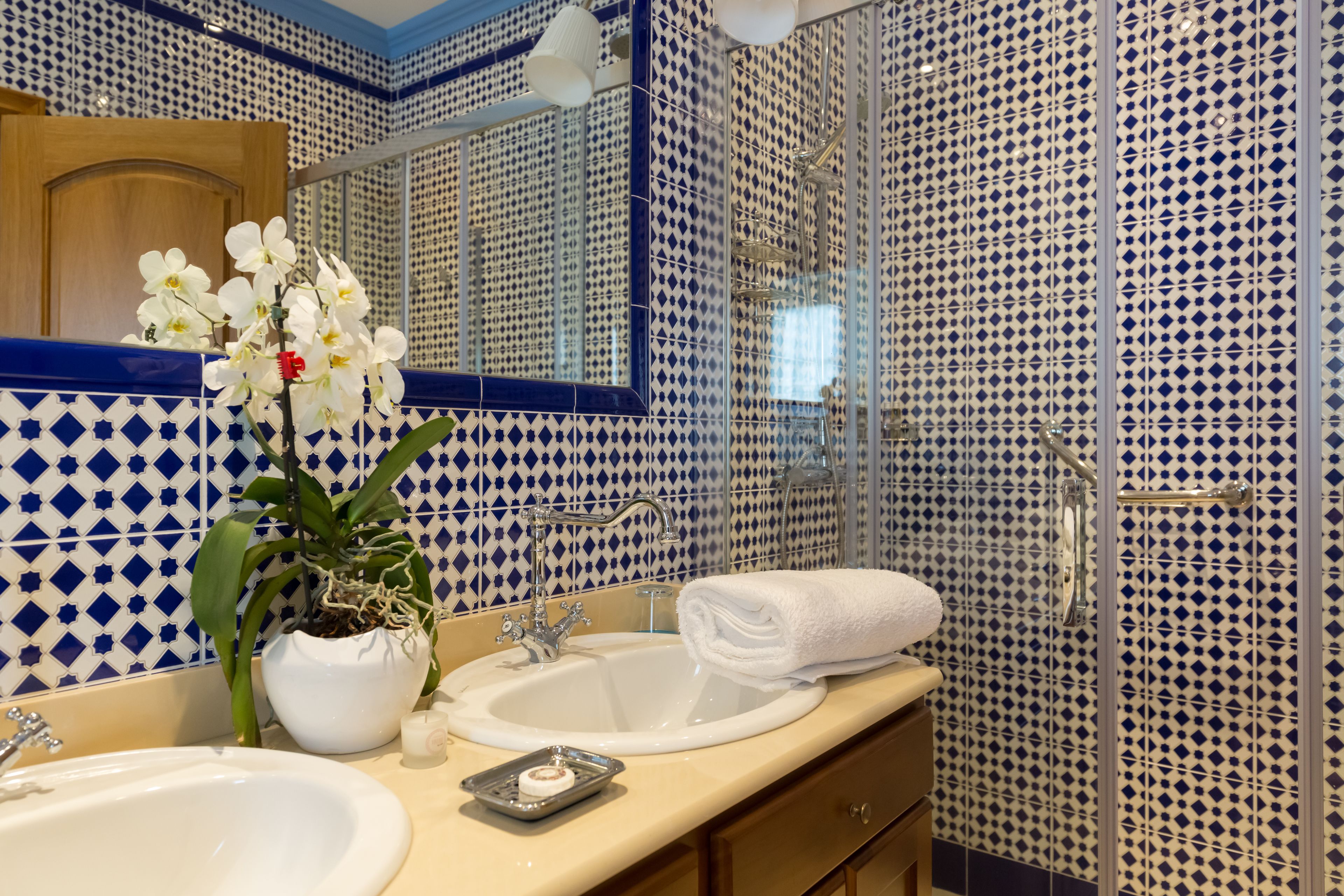 Een badkamer met een wastafel, spiegel en douche.