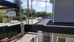 Un barrio residencial con una entrada porticada, un coche blanco estacionado en la calle y un edificio con un cartel que dice "CMA CGM".