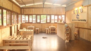 Interior rústico de madera con bancos largos y una mesa de recepción.