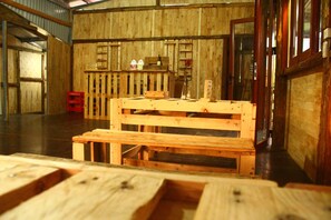 A rustic wooden interior with a wooden bench, a small table, and a vase with a flower. - Sapa Terrace View Homestay - Hostel (Ta Van)