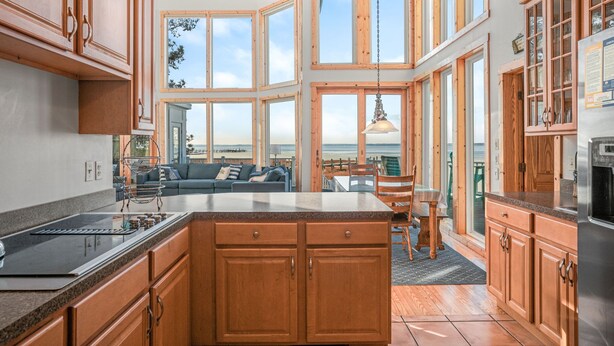 Una cocina moderna con armarios de madera, una isla grande y vistas al exterior.