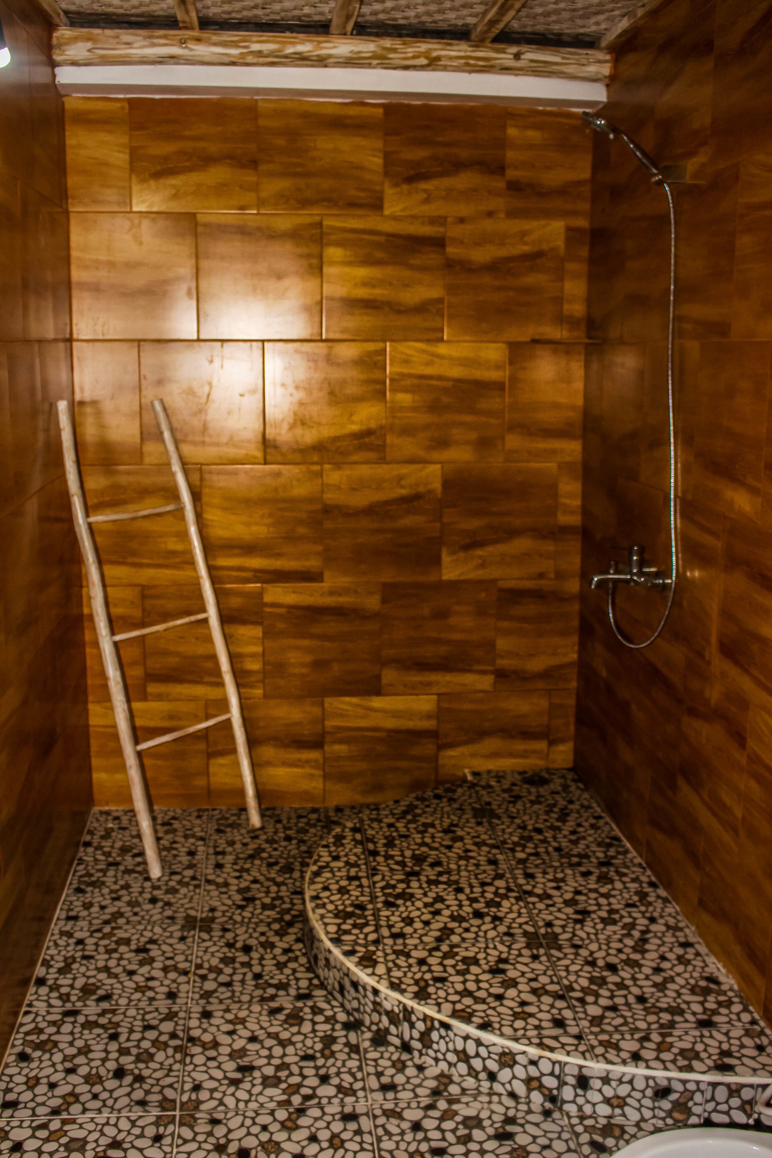 A bathroom with wooden walls, a tiled floor, and a shower.