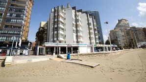 Un hotel frente a la playa con varios pisos y balcones.