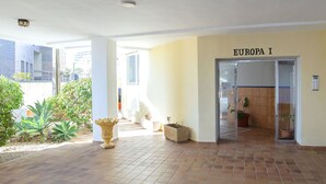 Un espacio interior amplio con piso de baldosas, una gran maceta decorativa y una puerta con la leyenda 'EUROPA I'.