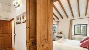 A wooden-framed bedroom with a bed, a nightstand, and a window with curtains. - Wonderful private villa for 4 people with A/C, WIFI, TV and terrace (Alcúdia)