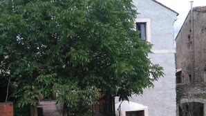 A building with a wooden fence and a gravel path leading to a door. - RENTAL DOMAINE DE LA BAUME - "LE MOULIN" (Cendras)