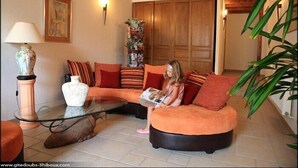 A cozy living room with a sofa, a glass coffee table, and a lamp.
