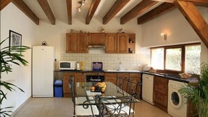 A kitchen with wooden cabinets, a refrigerator, a microwave, and a sink.