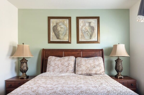 A bedroom with a bed, two nightstands, and two wall-mounted lamps. - Beautiful 6 Bedroom Home, 6 Miles from Disney World, South Facing Pool (Kissimmee)