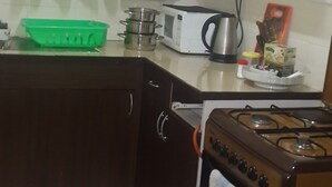 A kitchen with a stove, microwave, and various kitchen utensils.