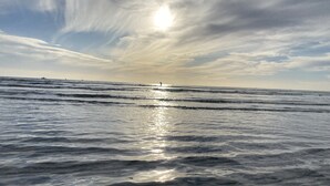 A beach with waves and a clear sky.