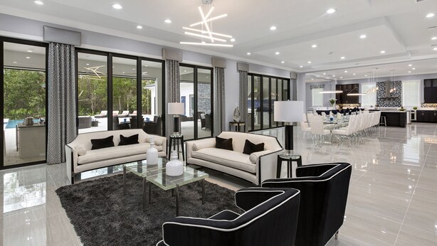 A spacious living area with a sofa, armchairs, and a glass coffee table. - The White House Of Reunion (Orlando)