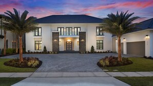 A modern two-story house with a symmetrical facade, large windows, and a central entrance. - The White House Of Reunion (Orlando)