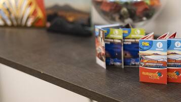 Ein Tresen mit Broschüren, einem Ventilator und einem Glasbehälter mit Snacks.