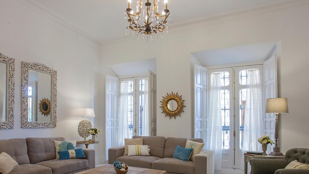 A spacious living room with a large chandelier, two sofas, a coffee table, and a side table with a lamp. - Aduana Presidential Living4malaga (Málaga)