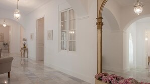 A spacious hallway with marble flooring, a large mirror, and elegant lighting fixtures. - Aduana Presidential Living4malaga (Málaga)