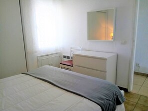 A bedroom with a bed, a white dresser, a chair, and a mirror on the wall. - Praiamar 4- Sea Front, Cozy, Private Parking (Quarteira)