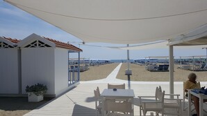 A beachside patio with white furniture and a view of the beach. - Casale Amati Il Frantoio, near Cinque Terre. (ortonovo)