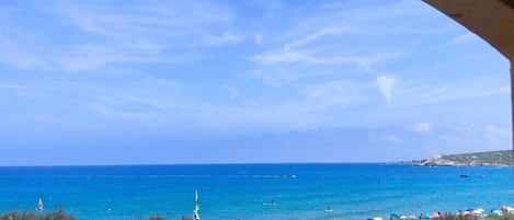 A beach view with parked cars and umbrellas.