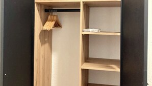 Un armario de madera con varias estantes y espacio para colgar.
