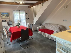 Un espace de vie chaleureux comprenant un coin repas, un canapé et un escalier.