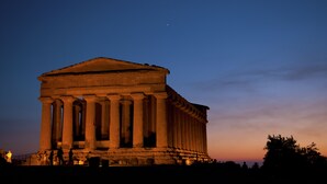 A large classical building with columns, likely a historical monument, under a twilight sky. - In the center of Agrigento (Agrigento)