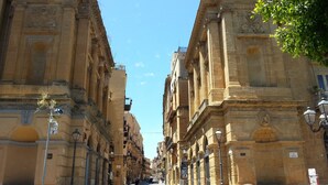 A street lined with historic buildings featuring ornate facades and classical architecture. - In the center of Agrigento (Agrigento)