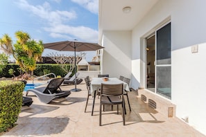 A patio with a pool, lounge chairs, a table, and an umbrella. - Luxury 3 bed/3 bath villa with private pool in the picturesque village of Peyia  (peyia)