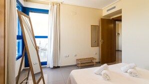 A hotel room with a bed, a wooden ladder, a bench, a mirror, and a door leading to another room. - ApartUP Patacona Orchard (Alboraya)